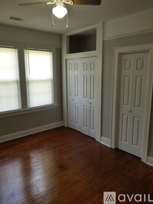 A room with wooden floors and white doors.