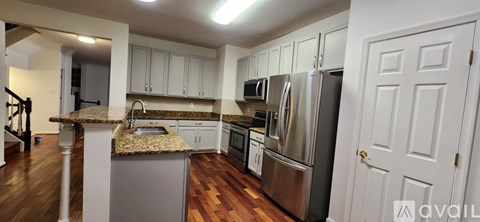 A kitchen with a granite counter top and stainless steel appliances.