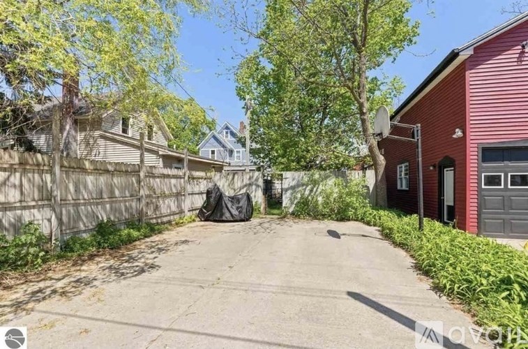 A red house with a driveway in front of it.