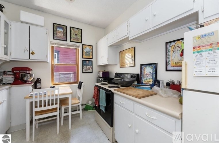 A kitchen with white cabinets and a white fridge.