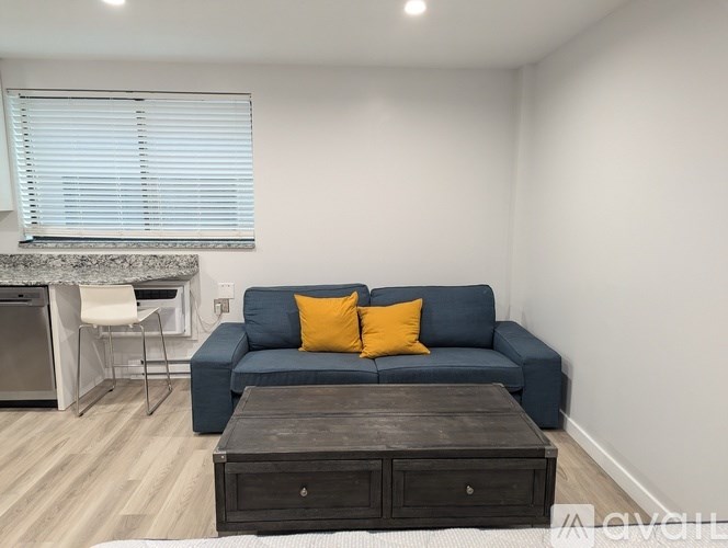 A living room with a blue couch and a wooden coffee table.
