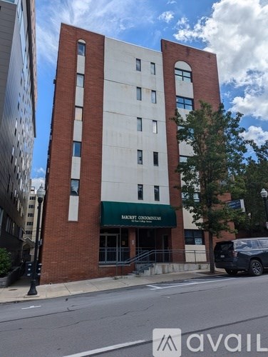 A tall red and white building with a green awning on the front.