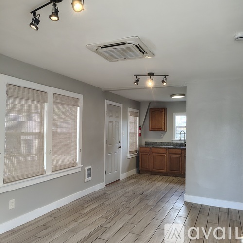 A room with a ceiling fan and wooden flooring.
