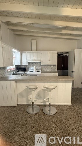 A kitchen with white cabinets and a granite countertop.