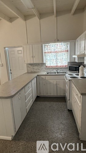A kitchen with white cabinets and a granite countertop.