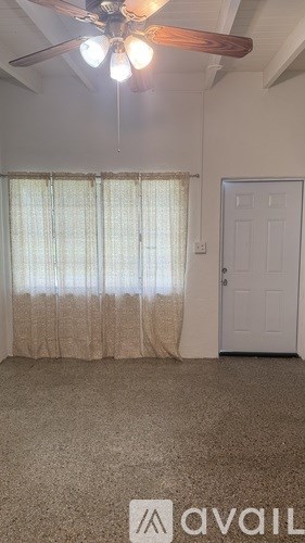 A room with a ceiling fan and a door.