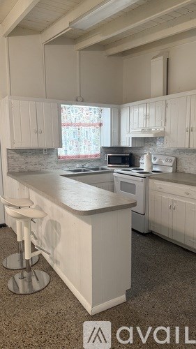 A kitchen with white cabinets and a marble countertop.