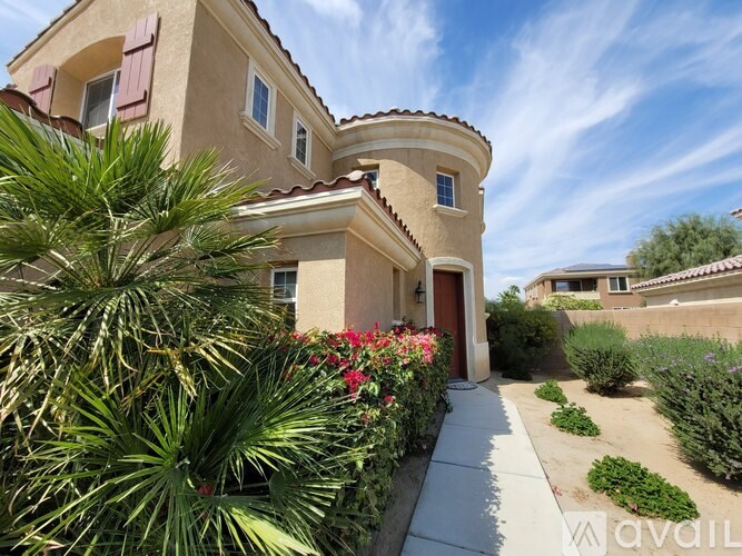 A house with a red door and a palm tree in front.