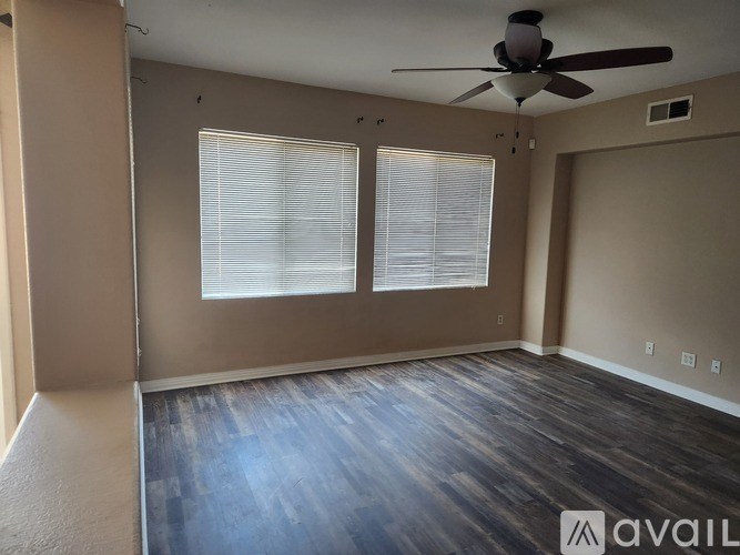 A room with a ceiling fan and carpeted floor.