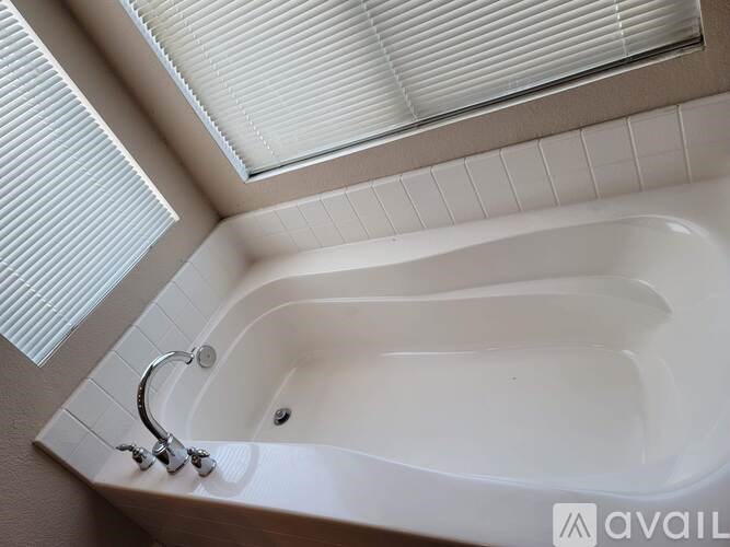 A white bathtub with a silver faucet is installed in a bathroom.