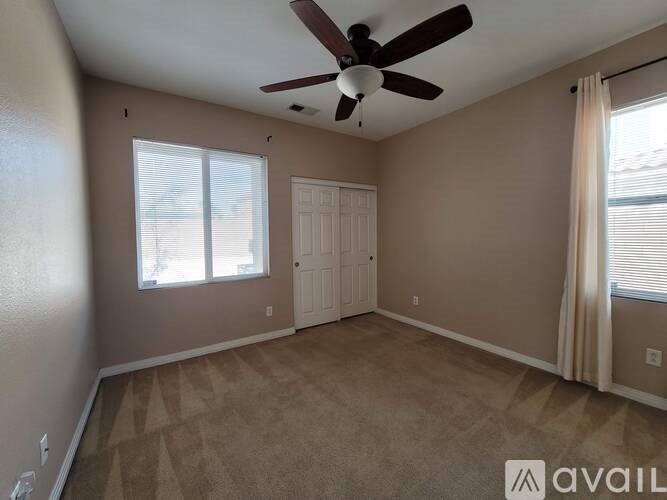 A room with a ceiling fan and a door.