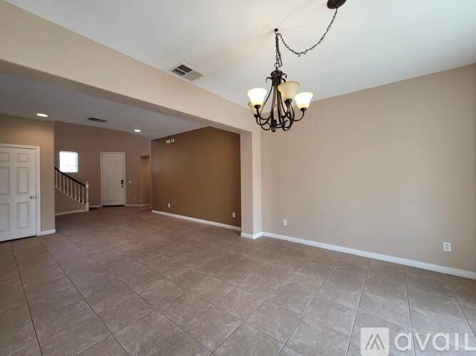 A large empty room with a chandelier hanging from the ceiling.