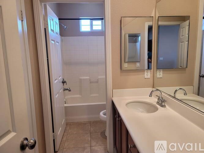 A bathroom with a sink, mirror, and shower.