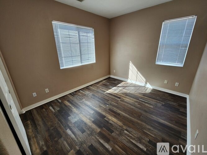 A grassy area with trees and a house in the background.