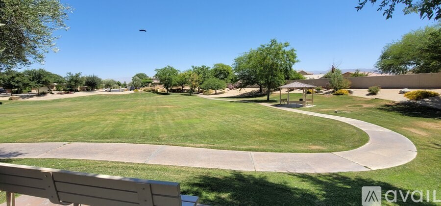 A park with a grassy field and a walking path.