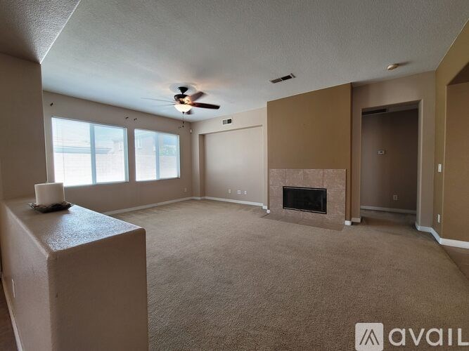 A living room with a fireplace and a ceiling fan.