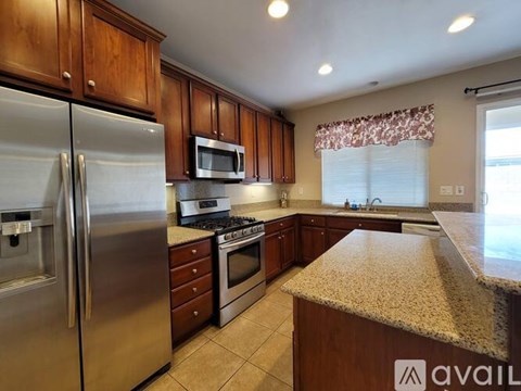 A kitchen with wooden cabinets and a granite countertop.