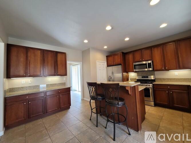A kitchen with brown cabinets and a bar area.