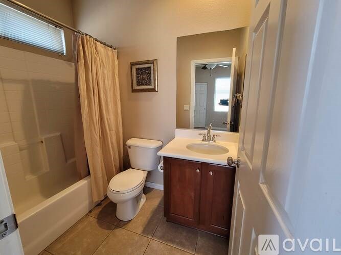A bathroom with a toilet, sink, and shower.