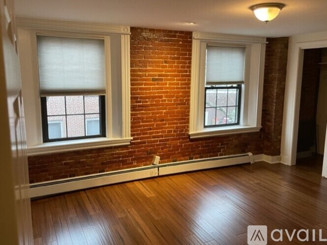 A room with a brick wall and wooden flooring.