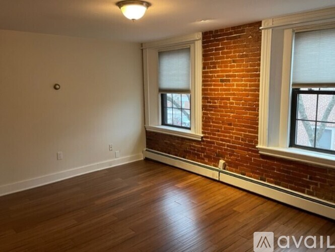 A room with a brick wall and wooden flooring.