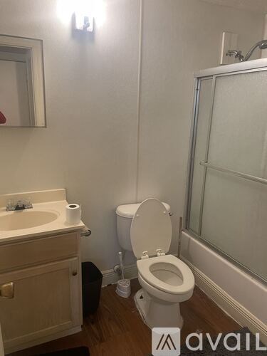 A bathroom with a toilet, sink, and mirror.