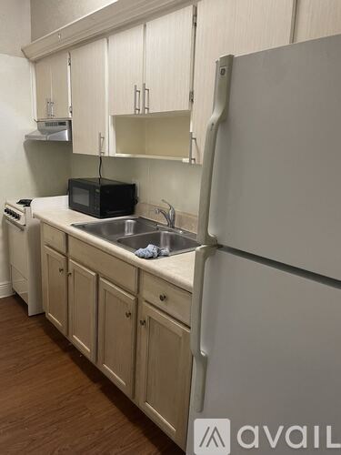 A kitchen with a white fridge and wooden cabinets.