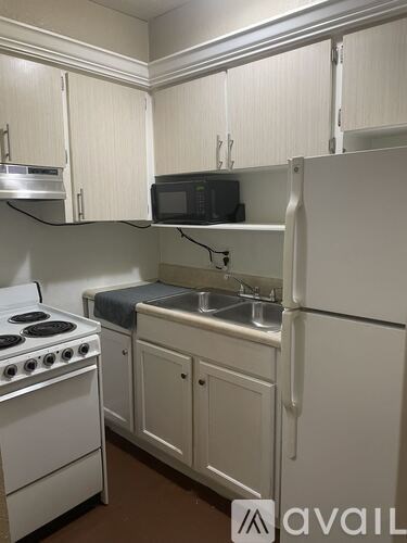 A kitchen with white appliances and cabinets.
