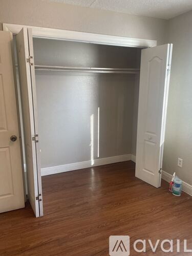 A room with a white door and a white closet with a shelf.