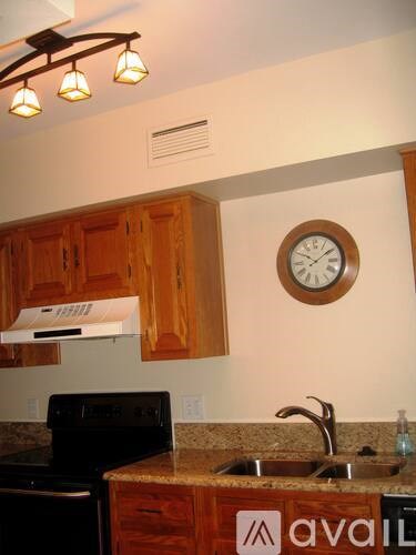 A kitchen with wooden cabinets and a black stove top oven.