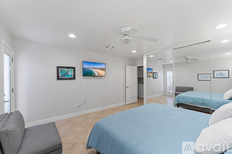 A bedroom with a blue bed and a ceiling fan.