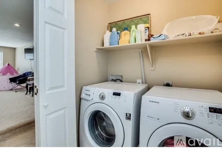 Two white front load washing machines in a laundry room.