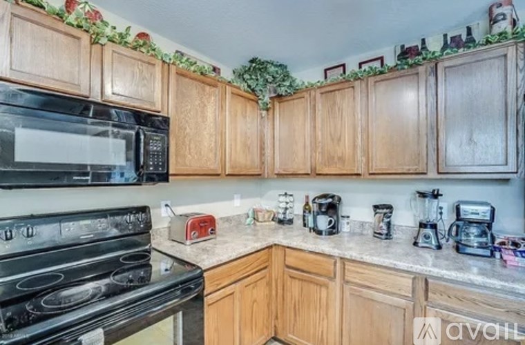 A kitchen with wooden cabinets and a black stove top oven.