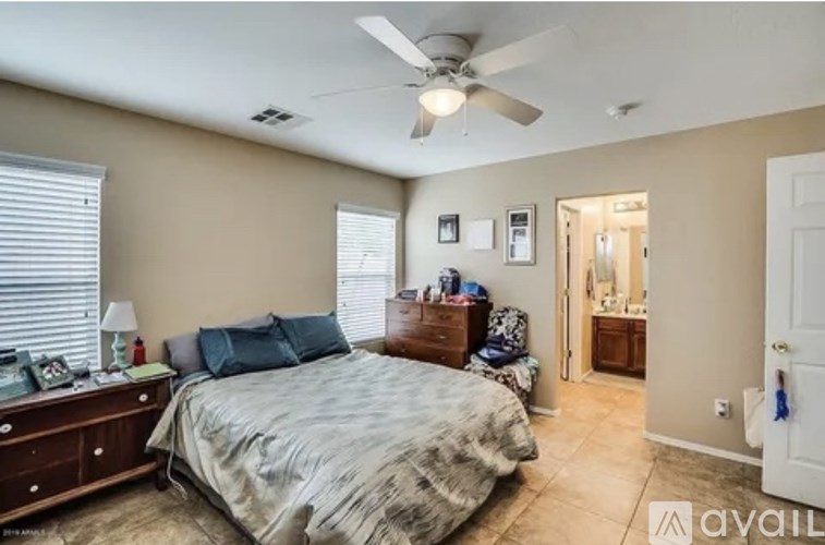 A bedroom with a bed, dresser, and ceiling fan.