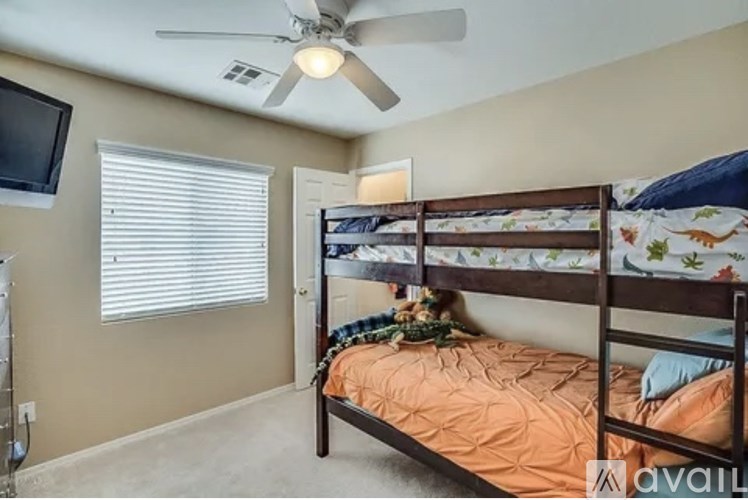 A bedroom with a bunk bed and a ceiling fan.