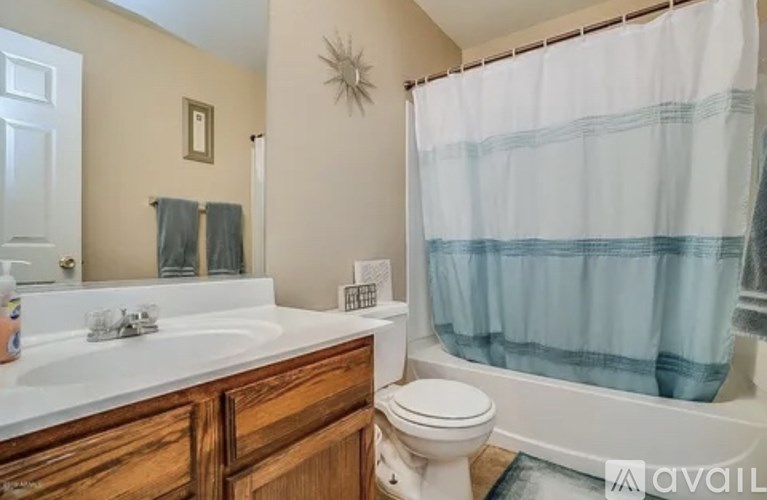 A bathroom with a toilet, sink, and shower.