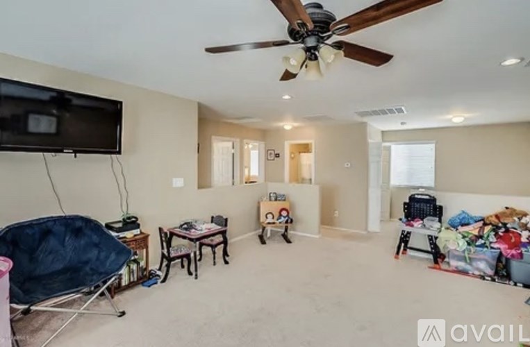 A living room with a ceiling fan and a television.