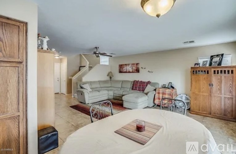 A living room with a white couch and a wooden cabinet.