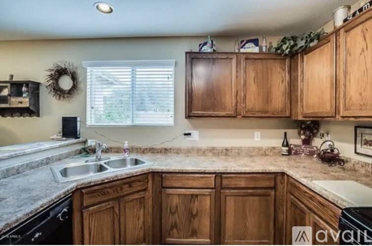 A kitchen with wooden cabinets and a granite countertop.