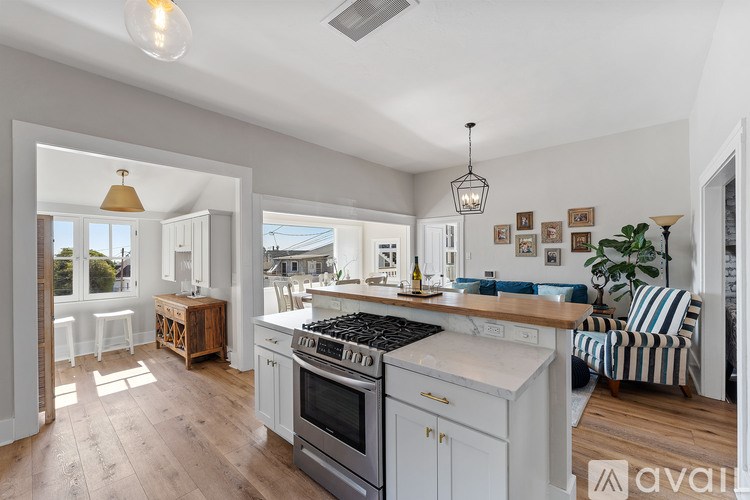 A modern kitchen with a large island and a view of the backyard.