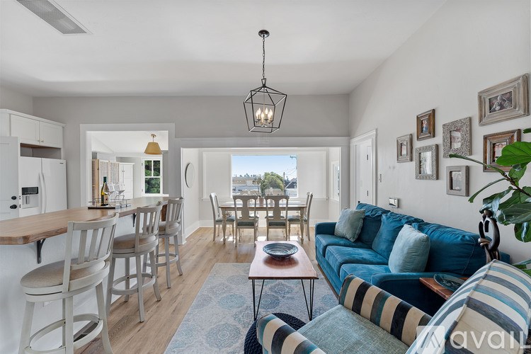 A living room with a blue couch and a dining table.
