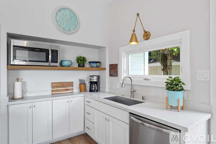 A kitchen with white cabinets and a black countertop.