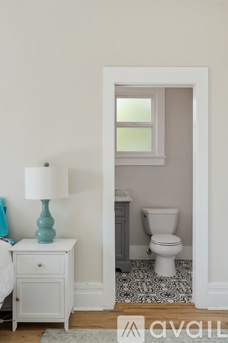 A white toilet sits in a bathroom next to a white door.
