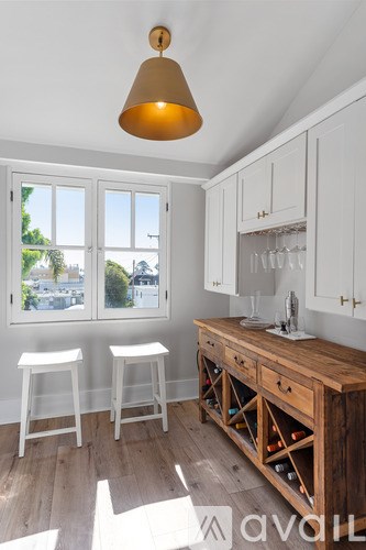 A kitchen with white cabinets and a wooden island.