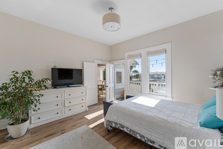 A bedroom with a bed, dresser, and television.
