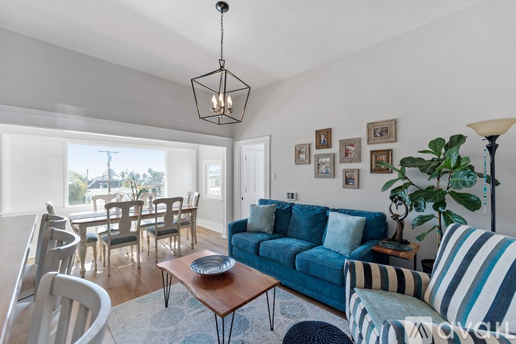 A living room with a blue couch and a wooden coffee table.