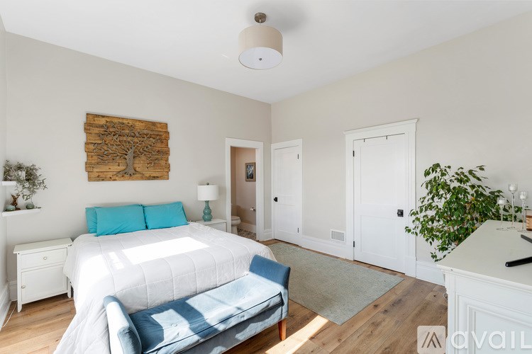 A bedroom with a white bed and blue pillows.