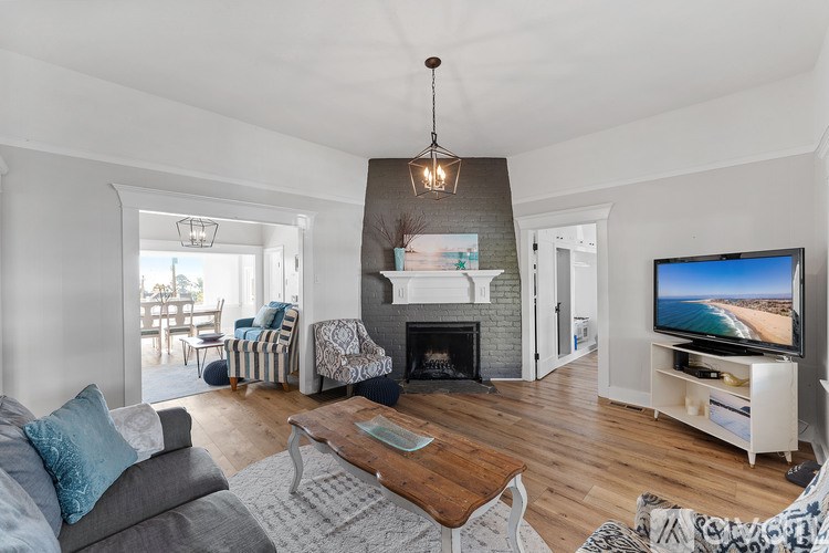 A living room with a grey couch and a fireplace.