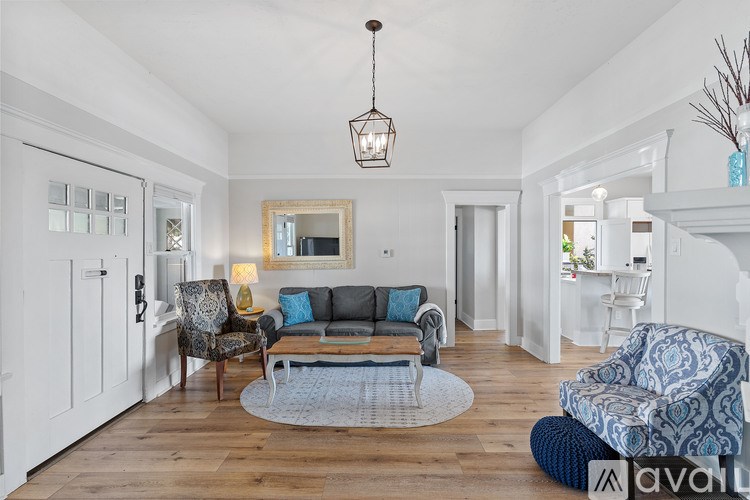 A living room with a grey couch and a white chair.