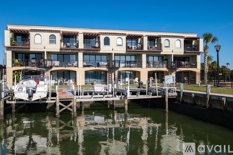 A boat is docked at a pier in front of a multi-story building.